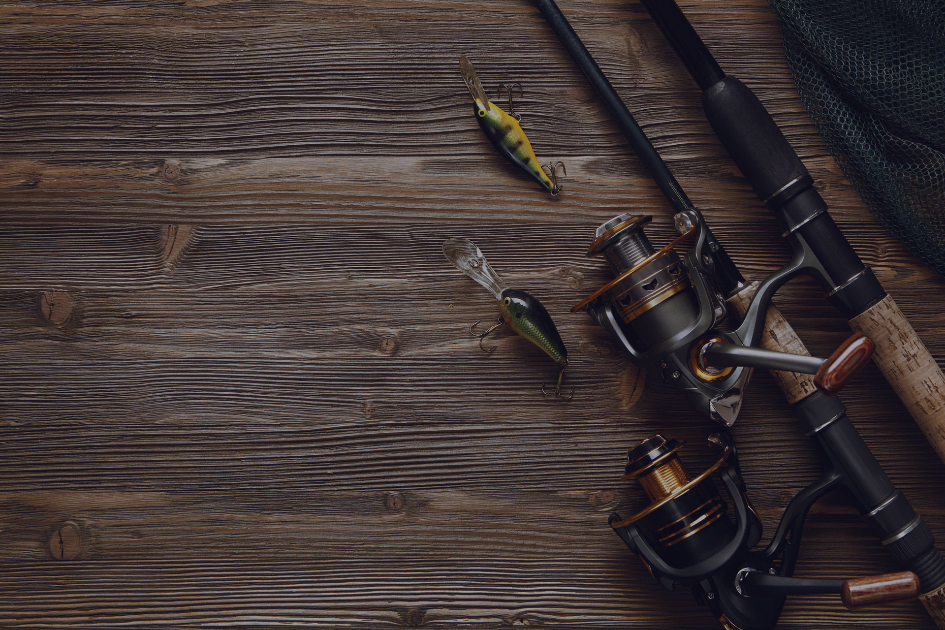 Fishing tackle - fishing spinning, hooks and lures on darken wooden background